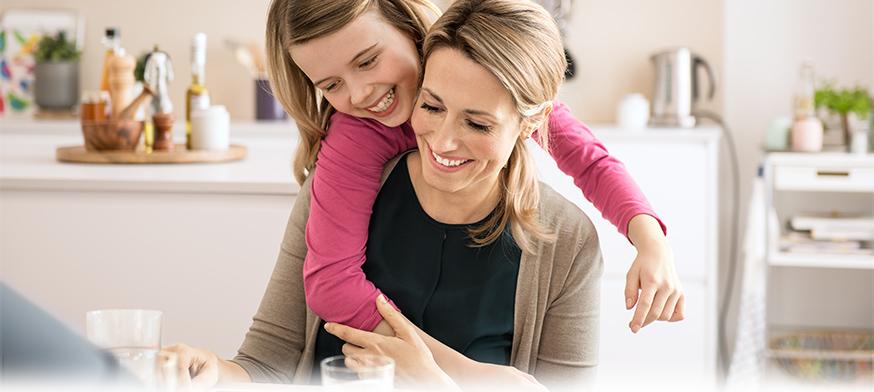 Mother and daughter laughing at kitchen table