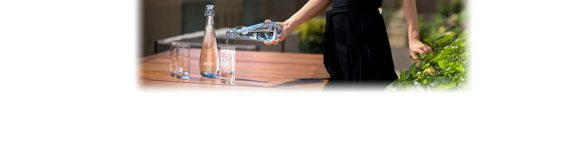 Woman pouring bottle of sparkling water
