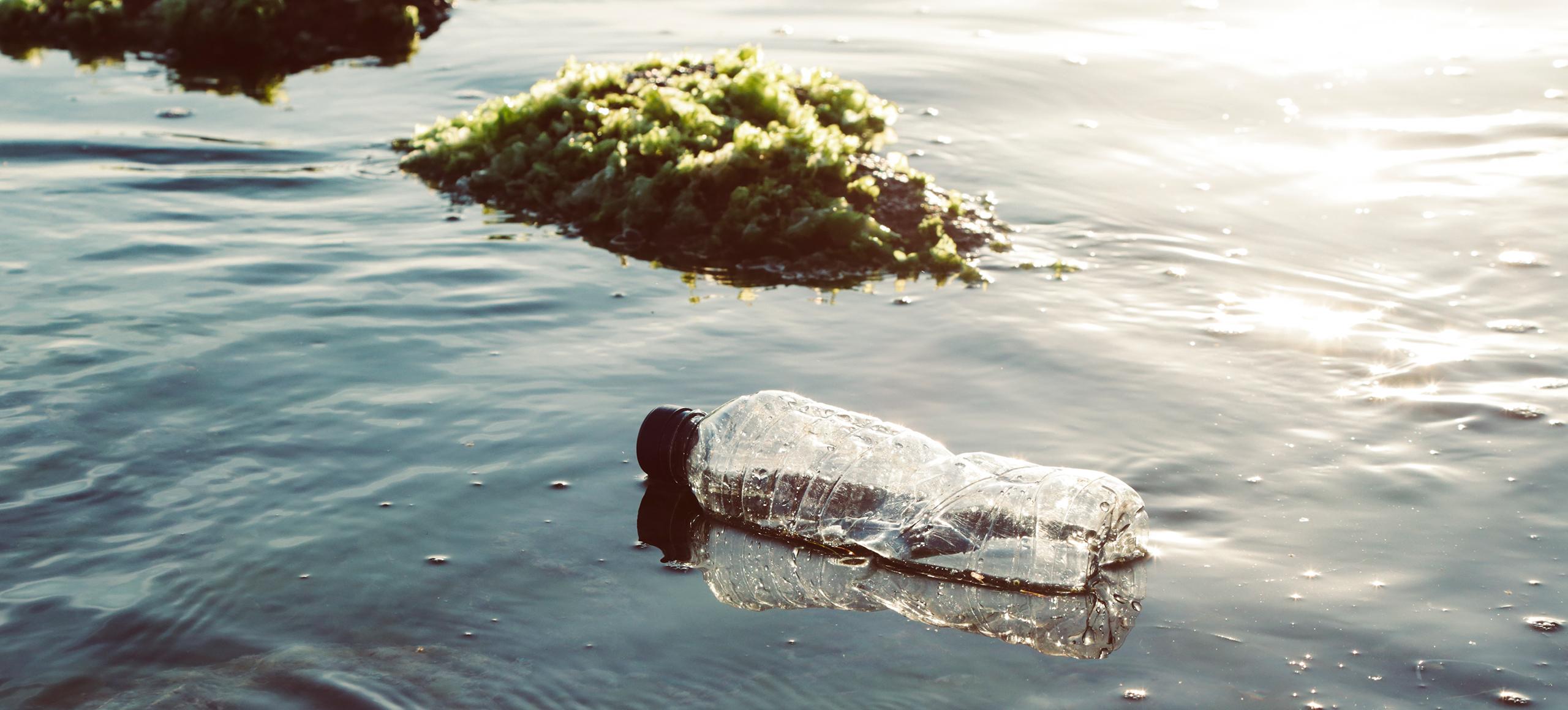 Single-use plastic bottle in ocean
