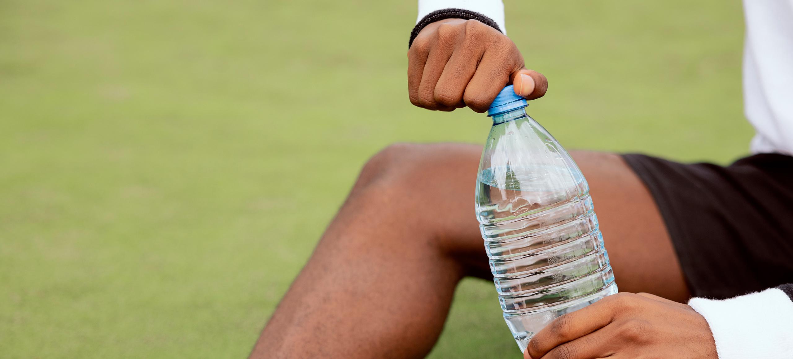 Tennis player with single-use plastic water bottle
