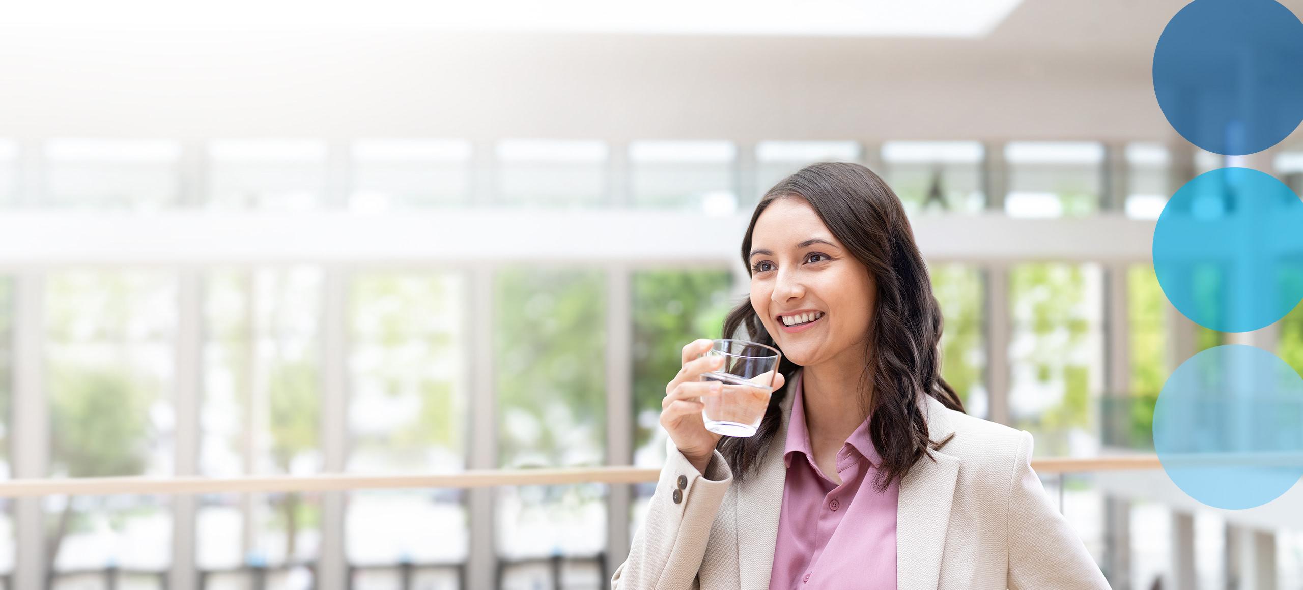 Woman in business suit holding water glass.
